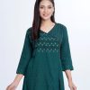 Green all-over printed Retro-wrap style Tunic in Viscose fabric. Designed with a V-neck, three-quarter sleeves. Embellished with embroidery, fancy button and pin tucks at the top front.