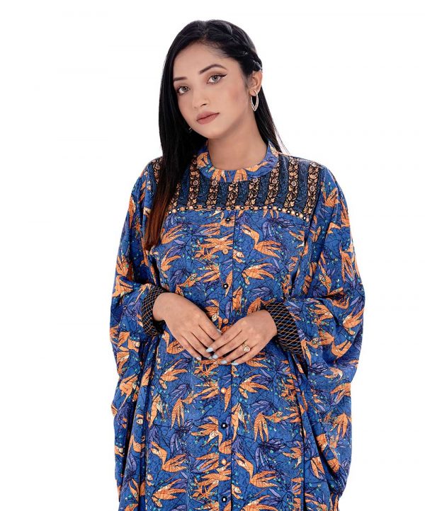 Blue Abaya style Tunic in printed Georgette fabric. Features a low mock neck and batwing sleeves. Embellished with embroidery at the top front