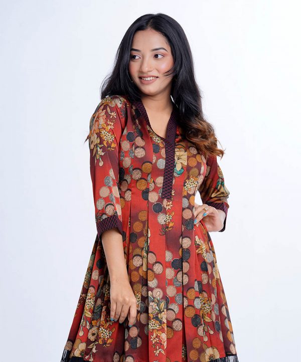 Red A-line Tunic in printed Crepe fabric. Features a kaftan collar with hook closure at the front and three-quarter sleeves. Embellished with swing stitched patch attachment at the collar and cuffs. Box pleats from waistline. Detailed with embroidered net attachment at the hemline.