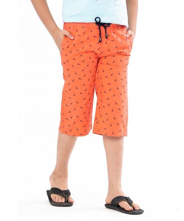 Coral orange all-over printed three-quarter pants in twill Cotton fabric. Five pockets, Covered elastic with adjustable drawstring at hemline & zipper fly.