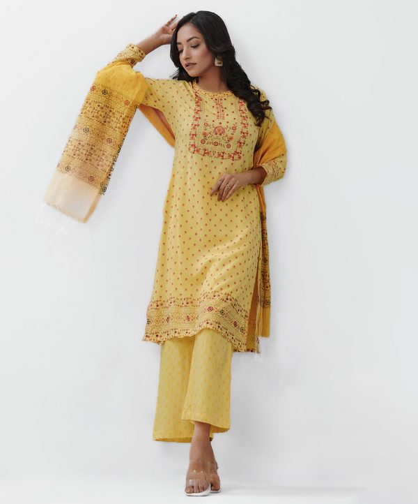 Yellow all-over printed Salwar Kameez in Viscose fabric. The Kameez is designed with a low mock neck and three-quarter sleeves. Embellished with embroidery at the top front. Button opening at the back. Complemented by palazzo pants and a half-silk dupatta.