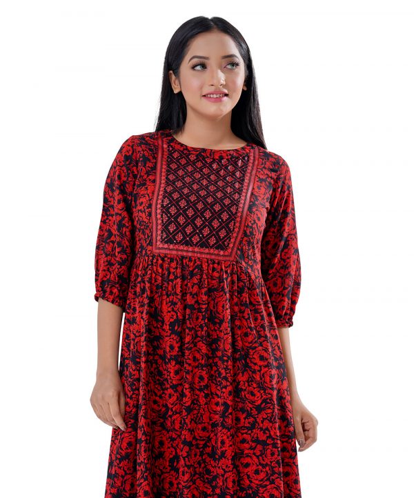 Maroon and Black Tunic in Printed Georgette fabric. Designed with a low mock neck and bishop sleeves. Embellished with embroidery at the top front and gathers from the waistline. Single button opening at the back. Unlined.