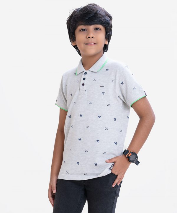 Kid boys short sleeves polo shirt in cotton pique fabric. Polka dot style tennis rackets printed.